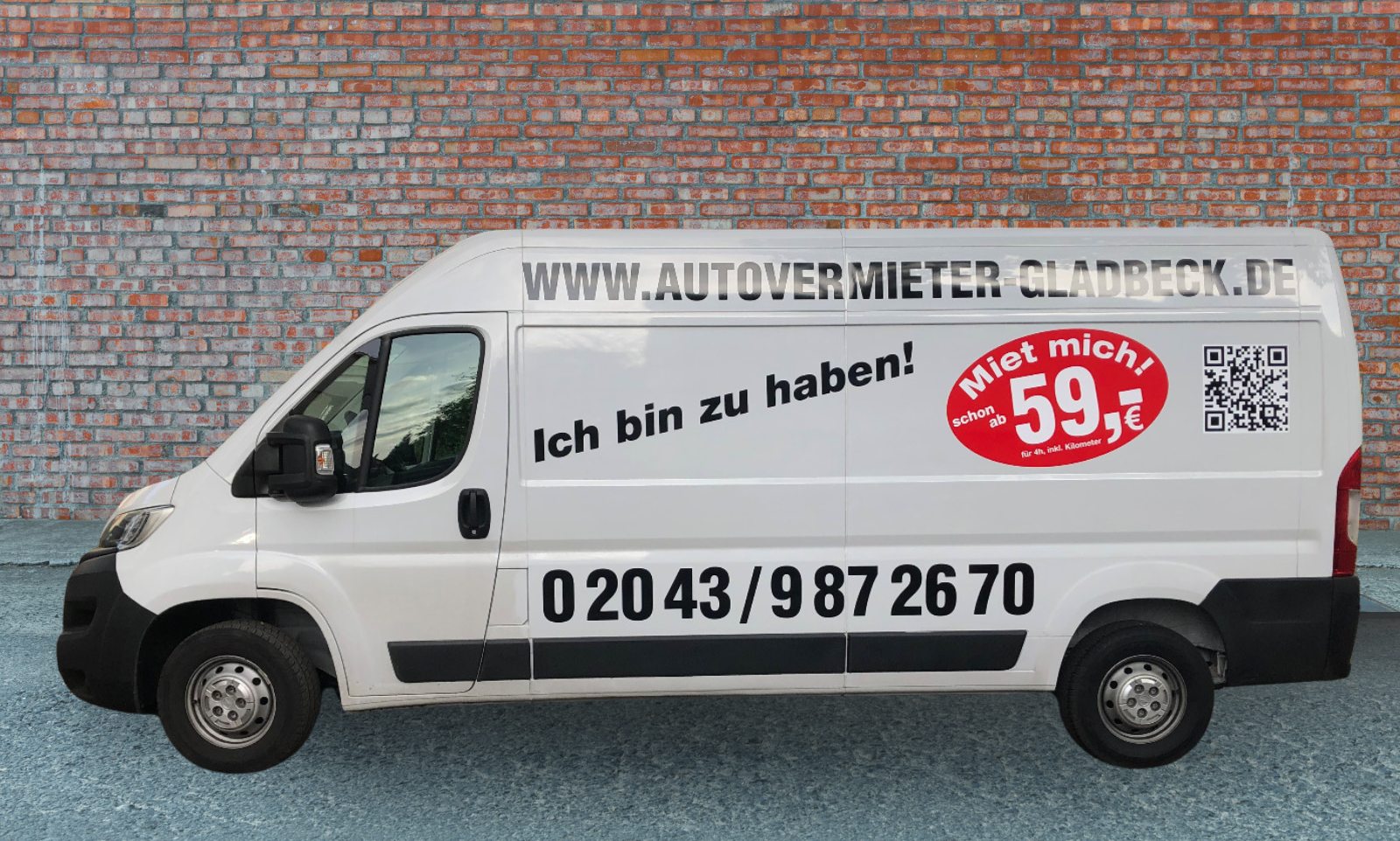 Weißer Transporter mit Beschriftung autovermieter-gladbeck.de vor einer Backsteinwand